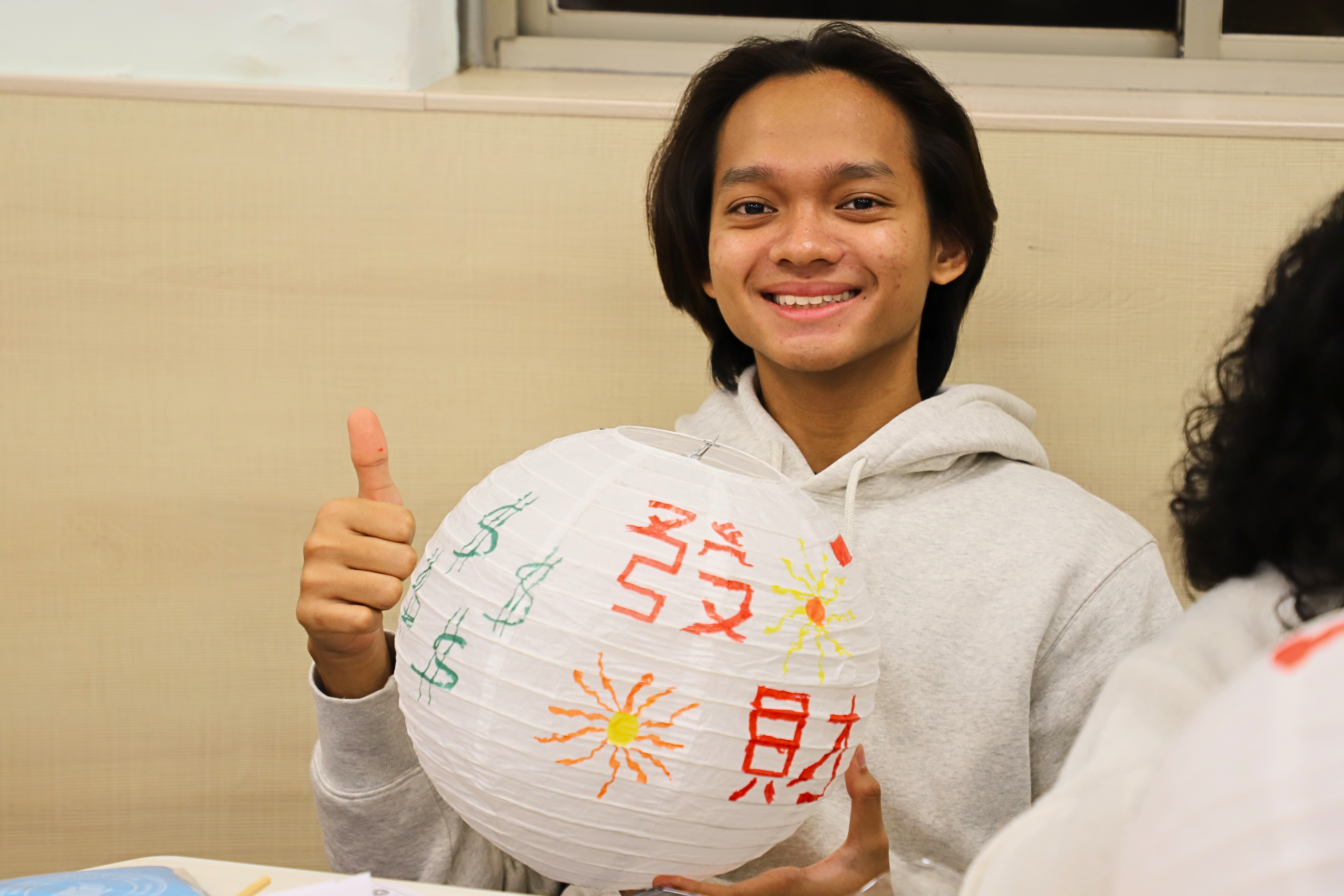 First-year ICI student Arbi writes his New Year wishes on a lantern. (Photo credit: ICI)