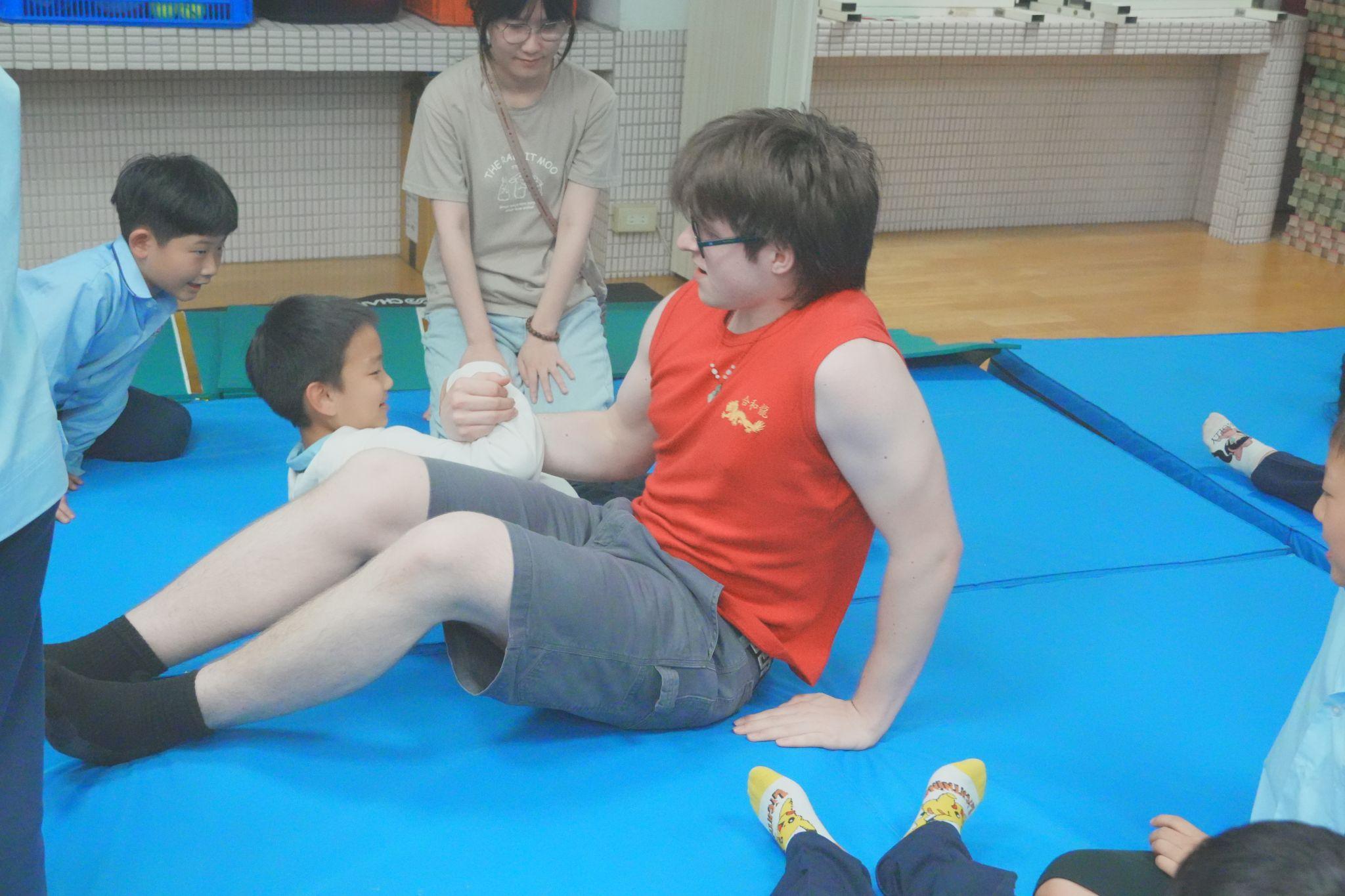 Canadian participant Mark Spitzer presents the Leg Wrestling game with a student. (Photo credit: ICI)