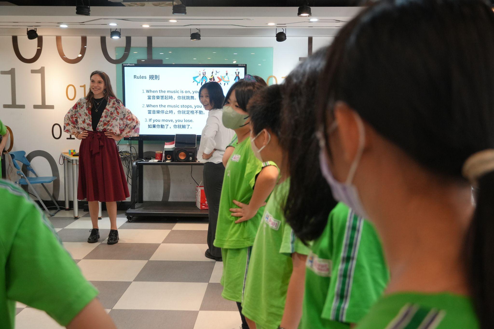 Participant Reka Koleszar introduces the “Freeze Dance” activity, encouraging students to engage in Hungarian traditional dance. (Photo credit: ICI)
