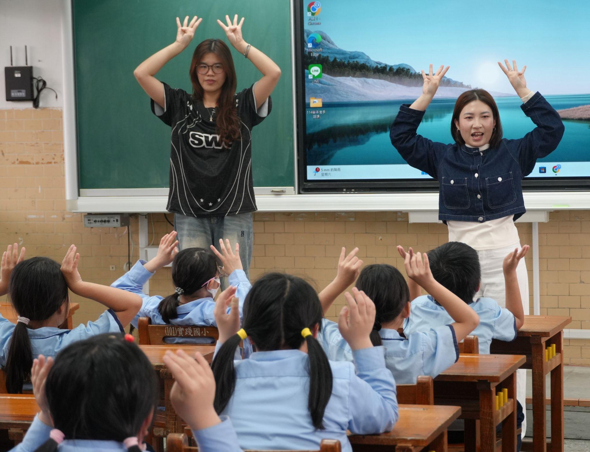 Vietnamese participants Chen Hongmei and Liang Ruan Jiaxin guide students in practicing the “Rabbit Game,” an action-based mimicry activity. (Photo credit: ICI)