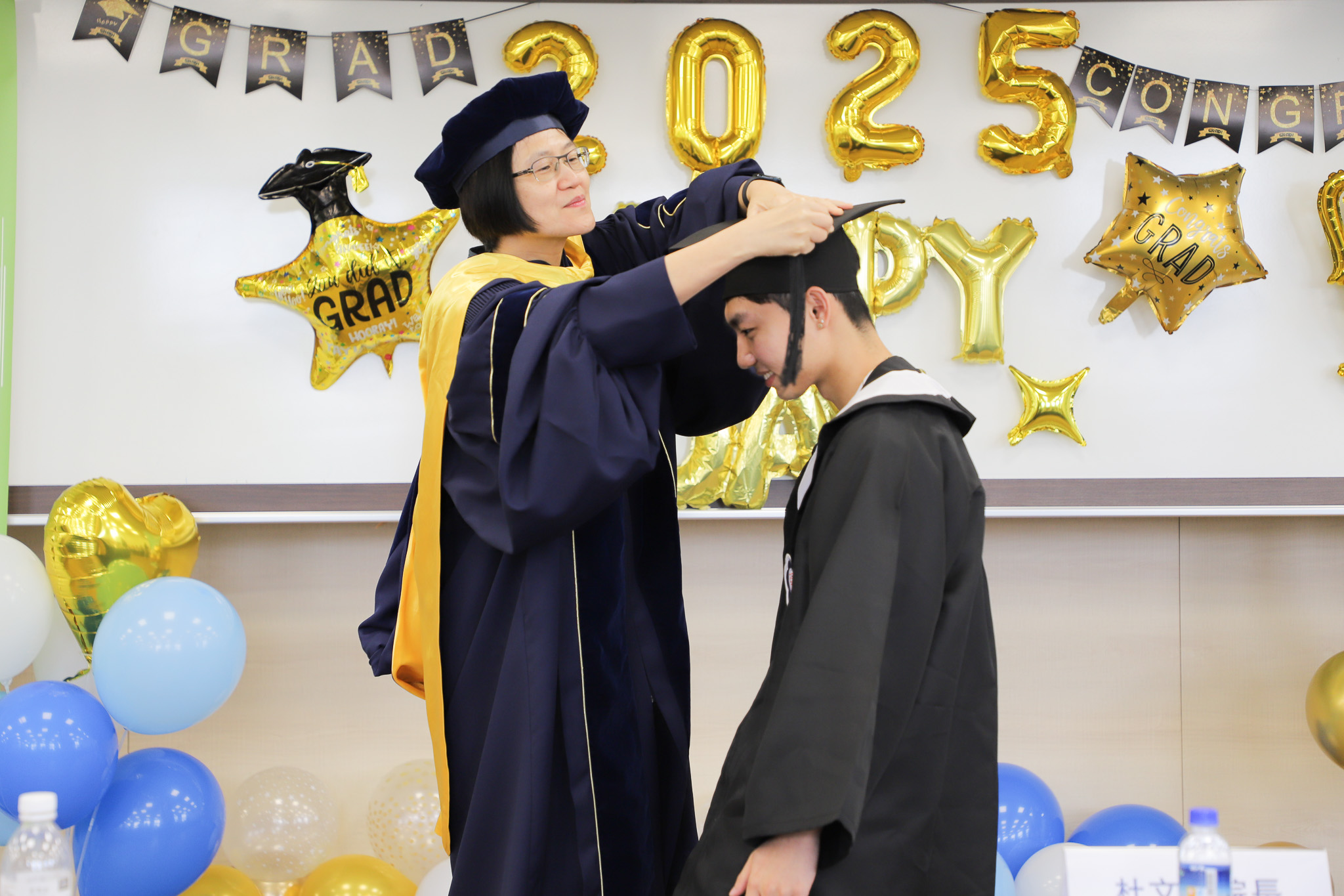 Dean Tu confers tassels upon graduating students during ICI's graduation celebration, offering her congratulations and best wishes. (Photo by ICI)