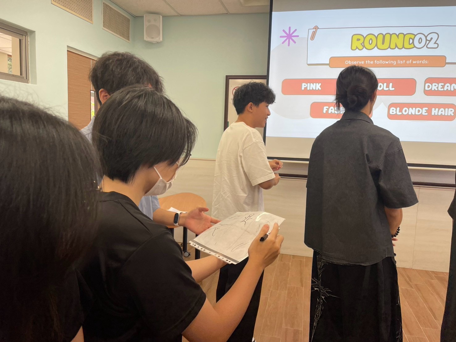 源：創新國際學院學生會） Freshmen communicate clues through drawings, getting to know one another through teamwork and interaction. (Photo courtesy of the ICISA)