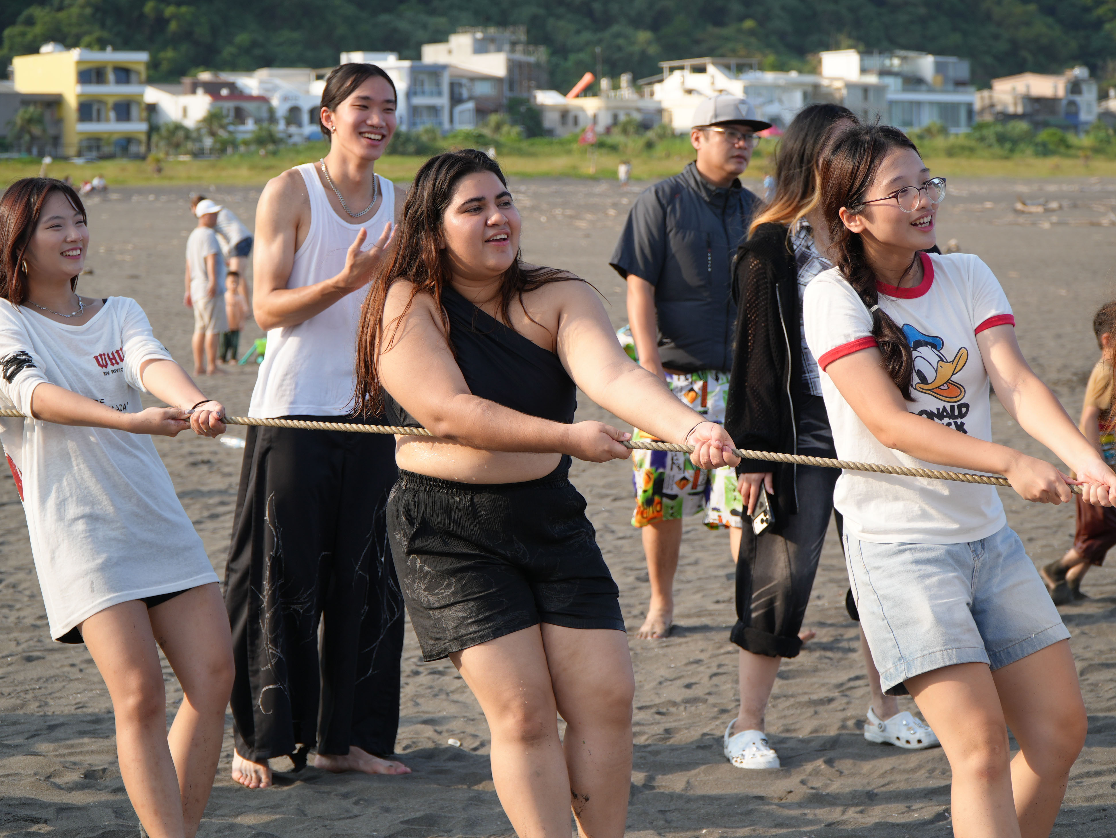 ICI students assist local fishermen in pulling in fishing nets at Waiao Beach in Yilan, gaining firsthand experience of local fishing practices. (Photo courtesy of ICISA)